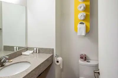 a bathroom with a sink and a mirror and a toilet at Motel 6-Fort Nelson, BC in Fort Nelson