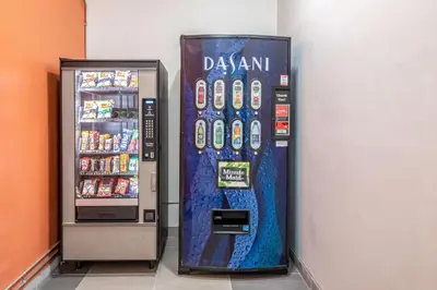 a drink vending machine next to a drink cooler at Motel 6-Fort Nelson, BC in Fort Nelson