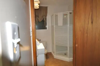 a small bathroom with a toilet and a glass door at Garden House in Courtenay