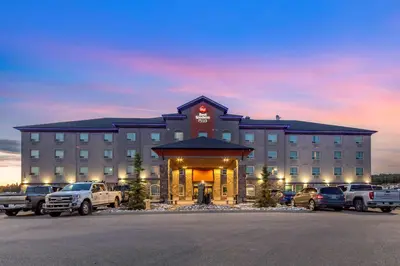 a hotel with cars parked in a parking lot at Best Western Plus Drayton Valley in Drayton Valley