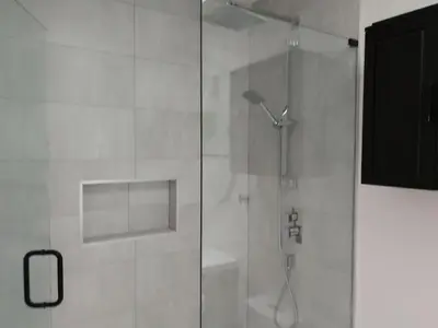 a shower with a glass door in a bathroom at Marpole Guest House in Vancouver