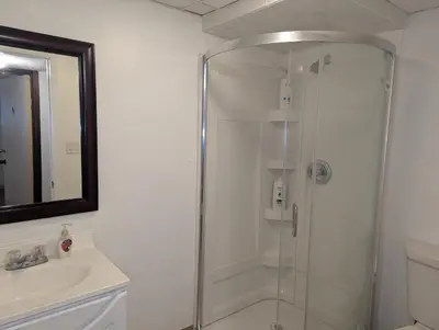 a shower with a glass door in a bathroom at Calgary Star Cozy Home in Calgary