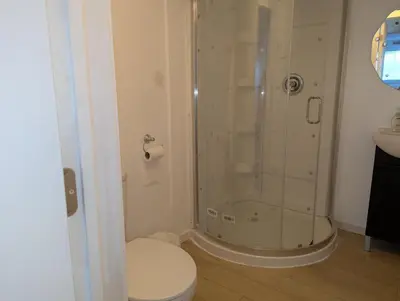 a bathroom with a shower with a toilet and a sink at Calgary Star Cozy Home in Calgary