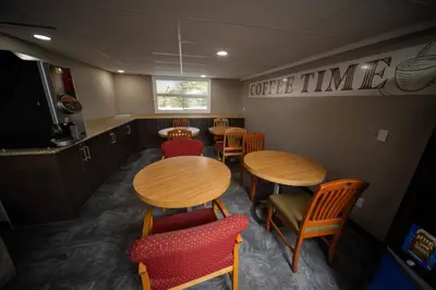 a dining room with wooden tables and red chairs at Northern Lights Inn in Fort Saint John