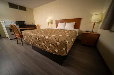 a hotel room with a bed and a kitchen at Northern Lights Inn in Fort Saint John