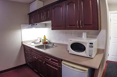 a kitchen with a sink and a microwave on a counter at Westwood Inn in Drayton Valley