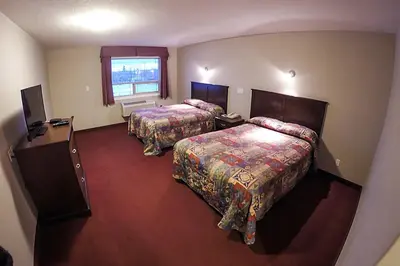a hotel room with two beds and a window at Westwood Inn in Drayton Valley