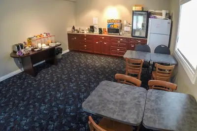 a conference room with tables and chairs and a refrigerator at Westwood Inn in Drayton Valley