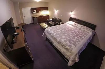 a hotel room with a bed and a living room at Westwood Inn in Drayton Valley