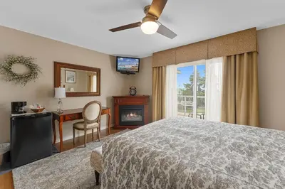 a bedroom with a bed and a desk and a fireplace at Lakeshore Inn in Cold Lake