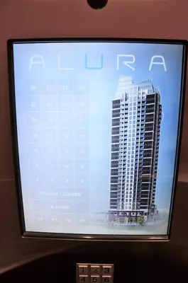 a television screen with a picture of a tall building at Monki Di Executive Suites - Alura in Calgary