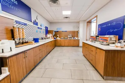 a large kitchen with wooden cabinets and a counter at Holiday Inn Express & Suites - West Edmonton-Mall Area by IHG in Edmonton