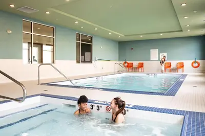 two people in a pool in a swimming pool at Holiday Inn Express & Suites - West Edmonton-Mall Area by IHG in Edmonton