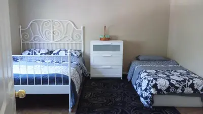 a bedroom with a bed and a dresser and a bed and a drawer at Brother Li Homestay in Calgary