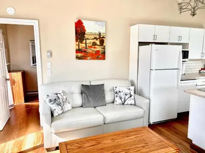 a living room with a white couch and a refrigerator at Peachland Beach Resort in Peachland