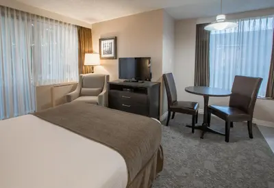 a hotel room with a bed and a table and chairs at The Embassy Inn in Victoria