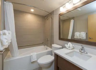 a bathroom with a sink and a toilet and a bath tub at The Embassy Inn in Victoria