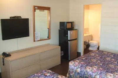 a small hotel room with a bed and a television at Trailside Inn in Lloydminster