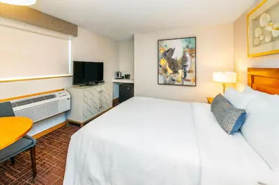 a hotel room with a bed and a flat screen tv at Banff Inn in Banff