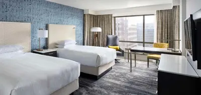 a hotel room with two beds and a desk at Hyatt Regency Vancouver in Vancouver