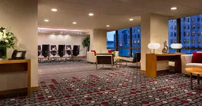 a lobby with a waiting room with chairs and tables at Hyatt Regency Vancouver in Vancouver
