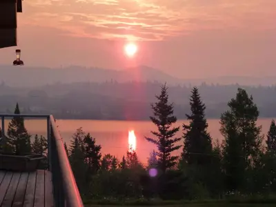 a sunset over a lake with a rainbow in the sky at Little Black Bear Lodge/B&B in Bridge Lake