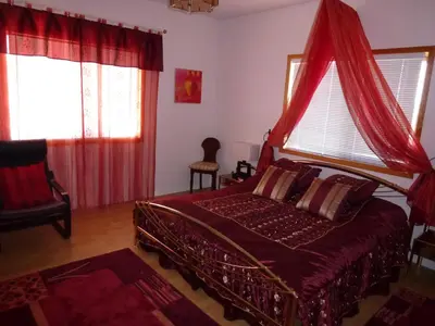 a bedroom with a bed with a red canopy at Little Black Bear Lodge/B&B in Bridge Lake
