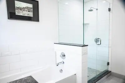 a white bathroom with a shower and a bathtub at Charltons Banff in Banff
