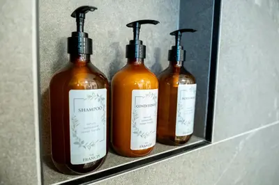 three bottles of soap on a shelf in a bathroom at The Francis Boutique Inn in Ucluelet