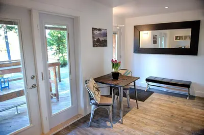 a dining room with a table and chairs and a balcony at The Francis Boutique Inn in Ucluelet