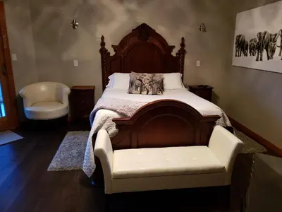 a bedroom with a bed and a chair in it at South Africa House Guest Lodge in Wainwright