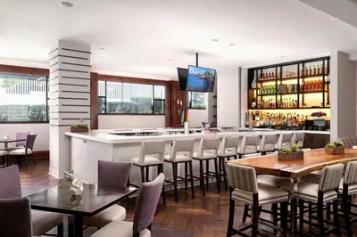 a restaurant with a bar with tables and chairs at Victoria Marriott Inner Harbour in Victoria