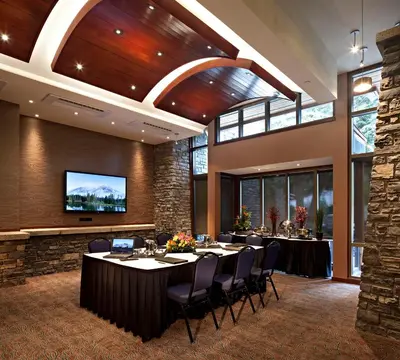 a conference room with tables and chairs and a flat screen tv at Royal Canadian Lodge in Banff