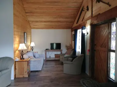 a living room with couches and a wooden ceiling at Wolfwood Guest Ranch in Clearwater