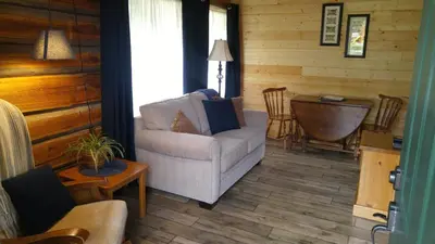 a living room with a chair and a table at Wolfwood Guest Ranch in Clearwater