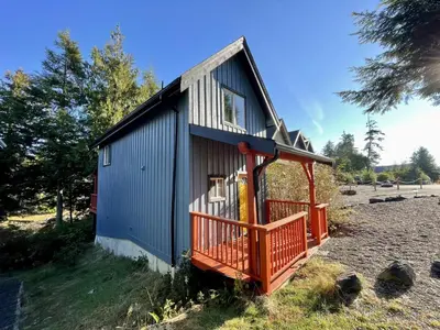 a small house with an orange front porch at Waterfront Timber-Frame Cottage! in Ucluelet