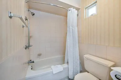 a bathroom with a tub and a toilet and a shower at Econo Lodge Inn & Suites in North Vancouver