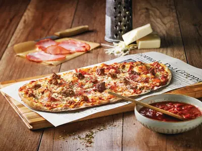 two pizzas sitting on a cutting board on a table at Holiday Inn Hotel & Suites Calgary South - Conference Ctr by IHG in Calgary