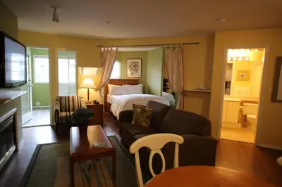 a living room with a couch and a bed at Times Square Suites Hotel in Vancouver