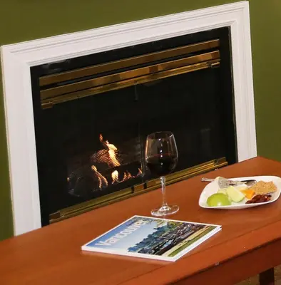a table with a plate of food and a glass of wine at Times Square Suites Hotel in Vancouver