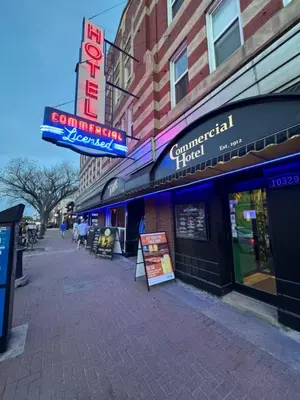 a building with signs on the side of a street at Commercial Hotel in Edmonton