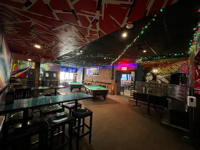 a bar with a pool table and ping pong tables at Commercial Hotel in Edmonton