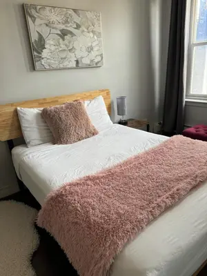 a bed with a pink blanket on top of it at Commercial Hotel in Edmonton