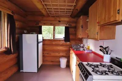 a kitchen with a white refrigerator and a stove at Rocky Ridge Resort-BC in Smithers