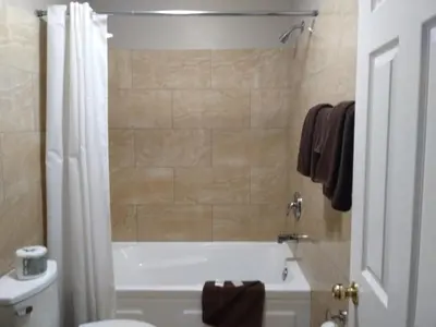 a bathroom with a tub and a toilet and a sink at Aries Motel in Edson
