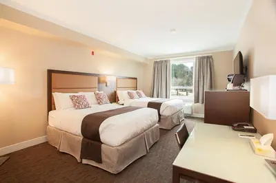 a hotel room with two beds and a desk at MStar Hotel in Kitimat