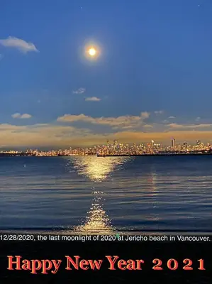 a moon over the water with a city in the background at Bay View House in Vancouver