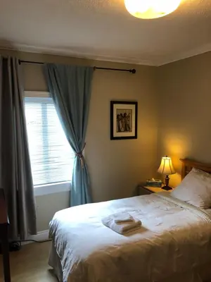 a bedroom with a large bed and a window at Cozy Bedrooms Guest House in Vancouver