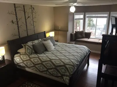 a bedroom with a bed and a couch and windows at Heart of Peachland in Peachland