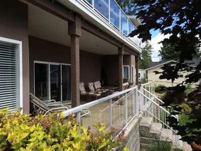 a porch of a house with chairs and tables at Heart of Peachland in Peachland